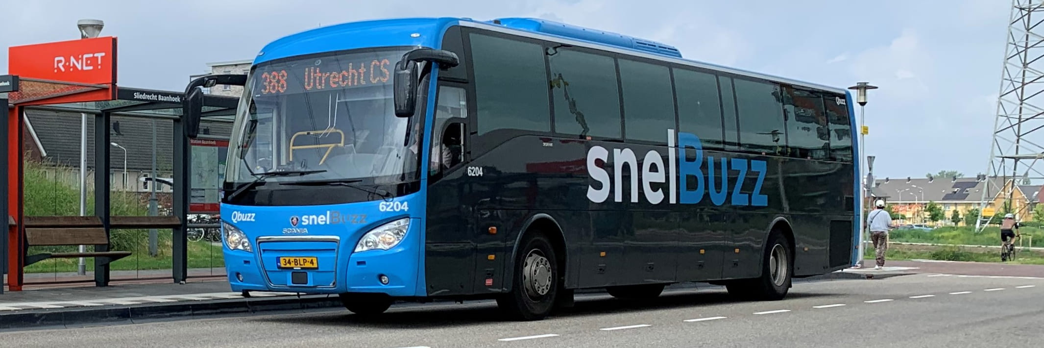 Een SnelBuzz staat bij een bushalte onder een viaduct